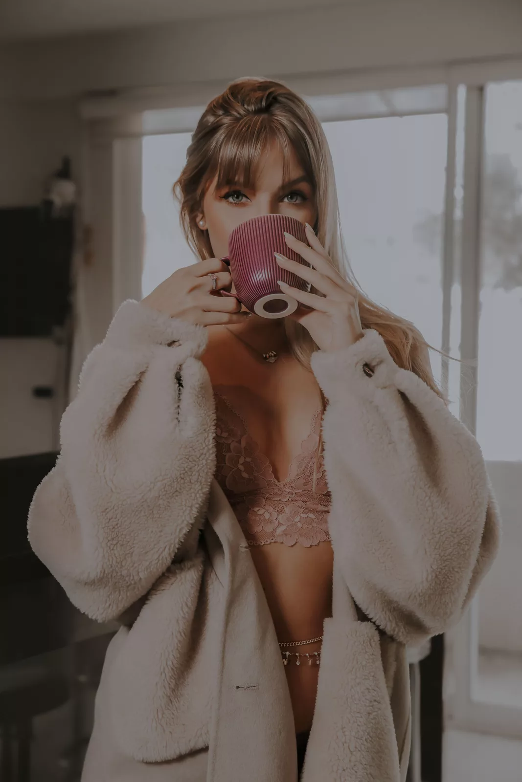 Lingerie rose sous un manteau beige
